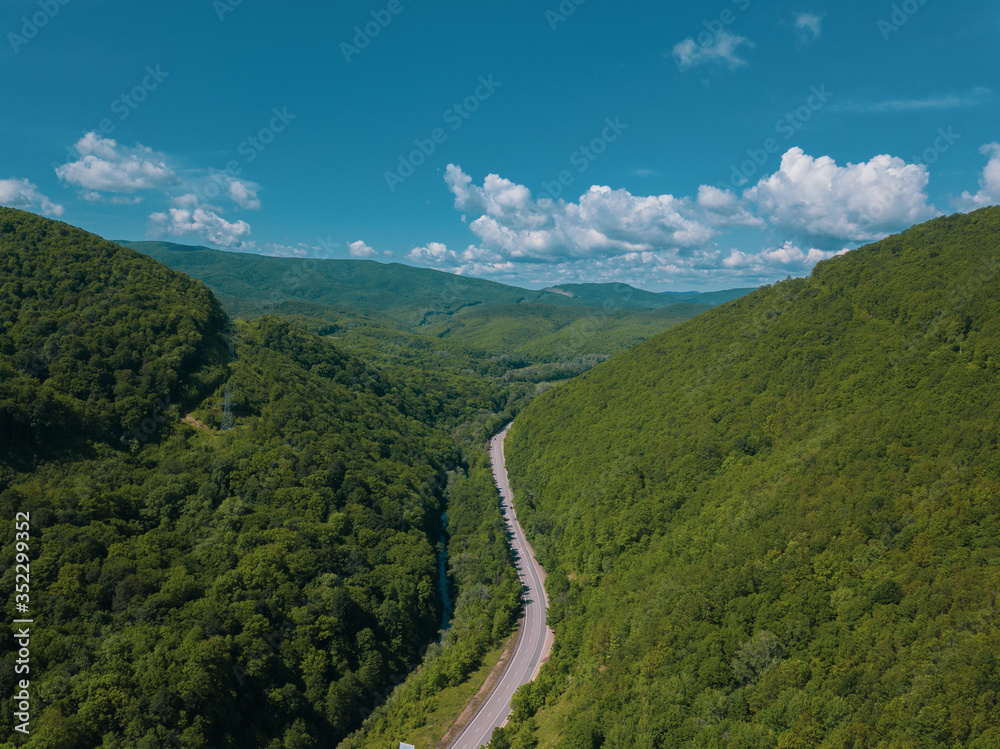 Aerial view of a rural highway between mountains
