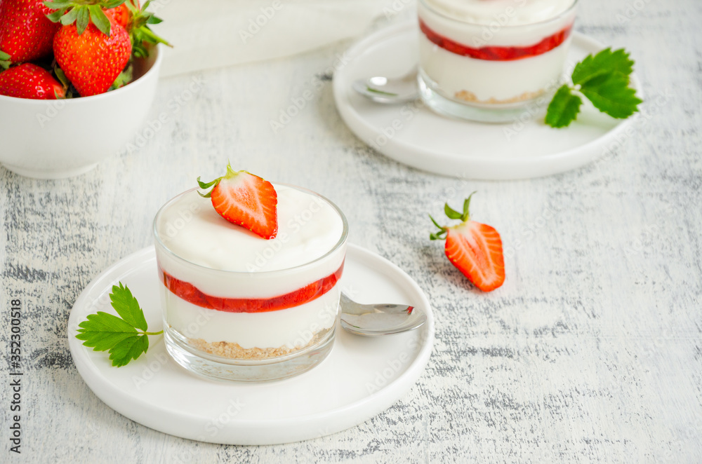 No baked strawberry cheesecake in a glass on a wooden background. Summer cold dessert. Horizontal, copy space. No baked strawberry cheesecake in a glass on a wooden background. Summer cold dessert. Horizontal, copy space.