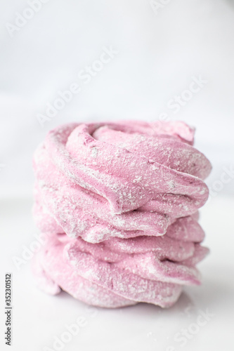 Sweets zefir or zefyr pink colored on a white plate