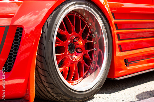 Red sports tuned car rear view of the wheel, close-up .