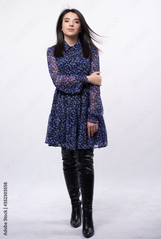 Happy beautiful woman in blue dress posing in studio isolated on white background,black long boots on his feet, Full length portrait Happy beautiful woman in blue dress posing in studio isolated on white background,black long boots on his feet, Full length portrait