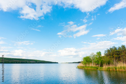 Water reservoir, forest and beautiful cloudy sky, calm landscape photography.