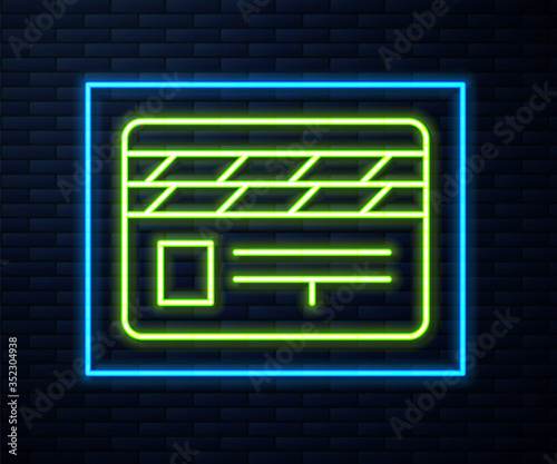 Glowing neon line Movie clapper icon isolated on brick wall background. Film clapper board. Clapperboard sign. Cinema production or media industry. Vector Illustration