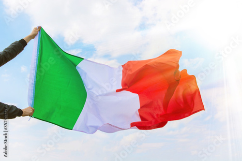 Waving Italy flag against blue sky  happy Republic Day in italian. national holiday of Italy  postcard with patriotic symbols