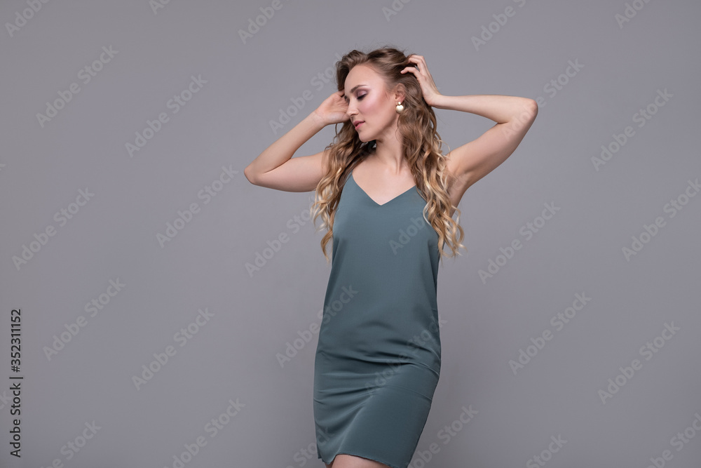 Fashion portrait of a young woman with a bright eye make-up and curly blond hair .on a gray background Fashion portrait of a young woman with a bright eye make-up and curly blond hair .on a gray background