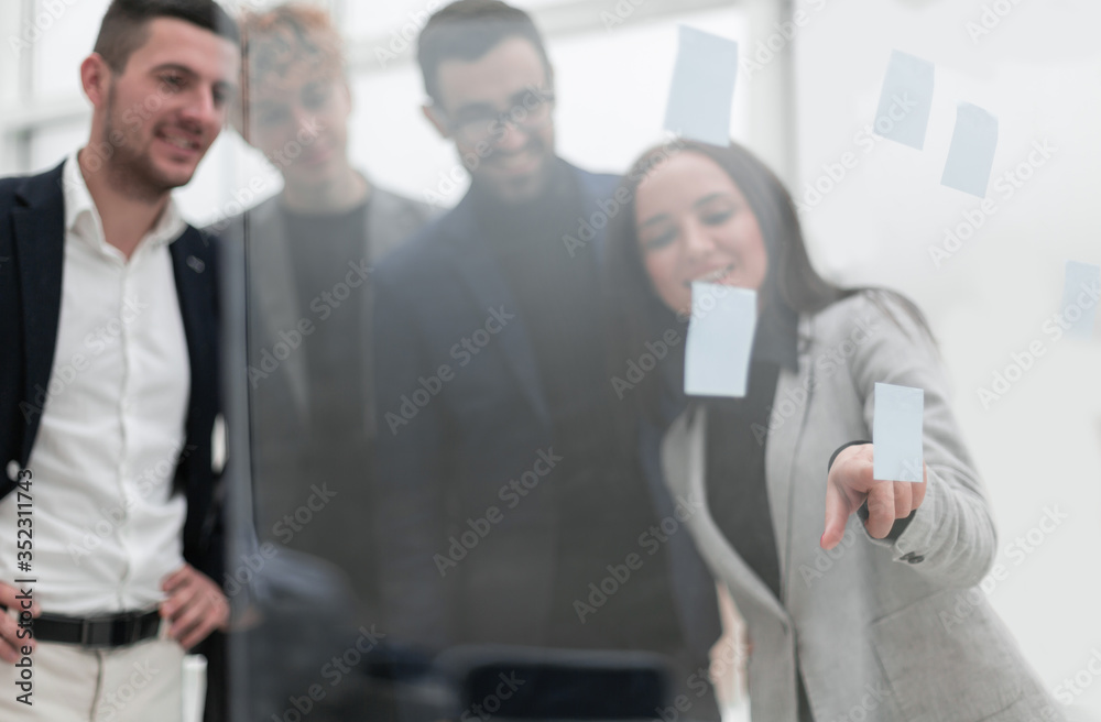 young business woman pasting sticky note on glass wall. young business woman pasting sticky note on glass wall.