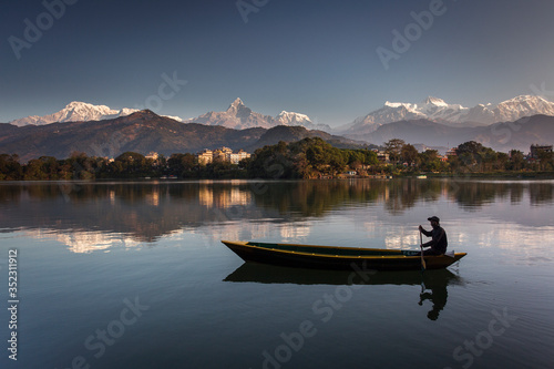 Beautiful landscape with Phewa Lake and boat on lake, mountains in background also as reflectaion on lake. Machapuchare-FIshtail, Annapurna and many others. Pokhara, Nepal © danmir12