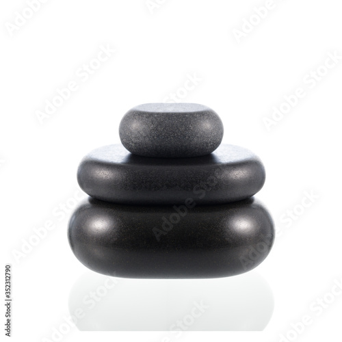 Pyramid of black basalt zen stones for hot massage isolated on white.