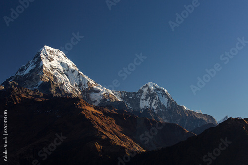 View of Annapurna South at sunset from Poon Hill with buddhist flags. Himalaya Mountains  Nepal