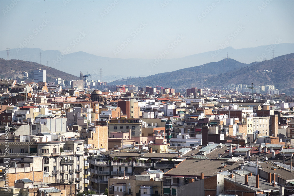 View of roofs of Barcelona surrounded with mountains from the hill of Montjuic View of roofs of Barcelona surrounded with mountains from the hill of Montjuic