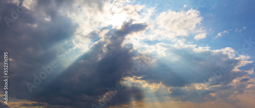 sun rays push through a dense cumulus clouds, beautiful natural sky background