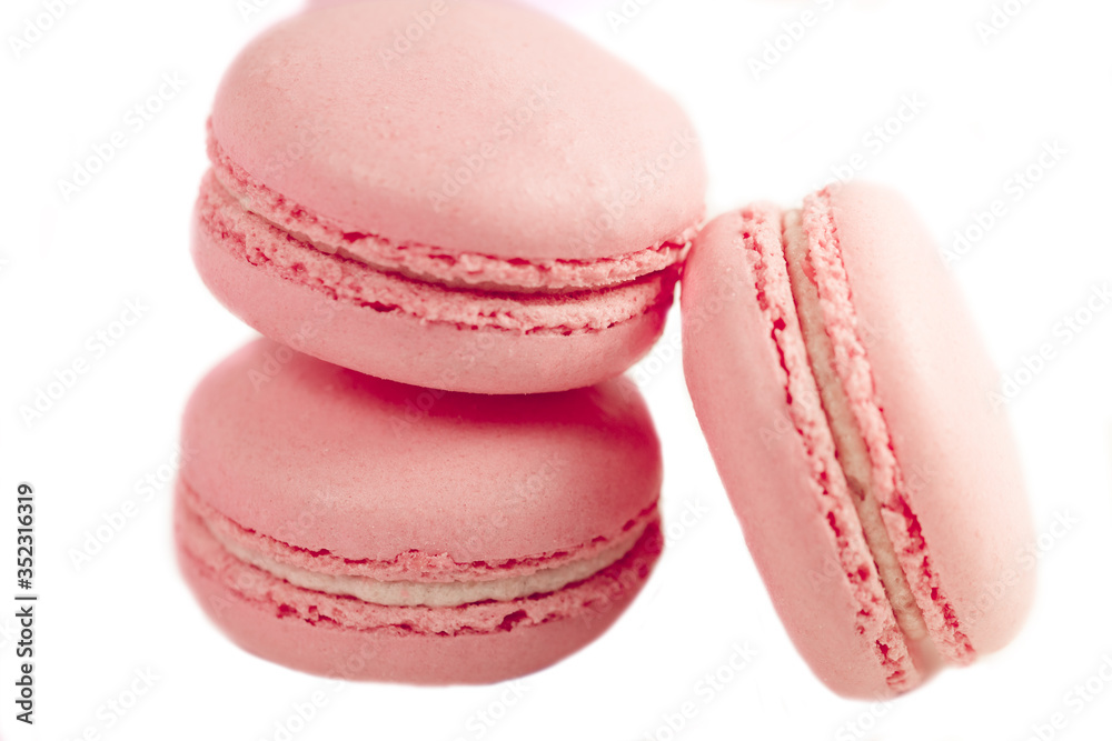 Delicious french dessert. Three gentle pastel soft pink cakes macaron or macaroon isolated on a white background Delicious french dessert. Three gentle pastel soft pink cakes macaron or macaroon isolated on a white background