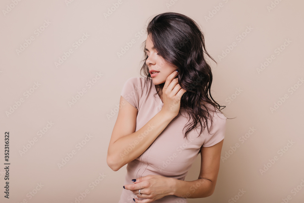 Photo indoors of tanned lady with blue manicure. Girl with wavy shiny hair posing in profile Photo indoors of tanned lady with blue manicure. Girl with wavy shiny hair posing in profile