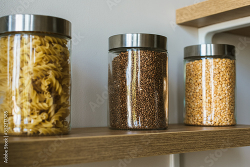 Different cereals in glass jars. Many seeds in transparent glass vessels
