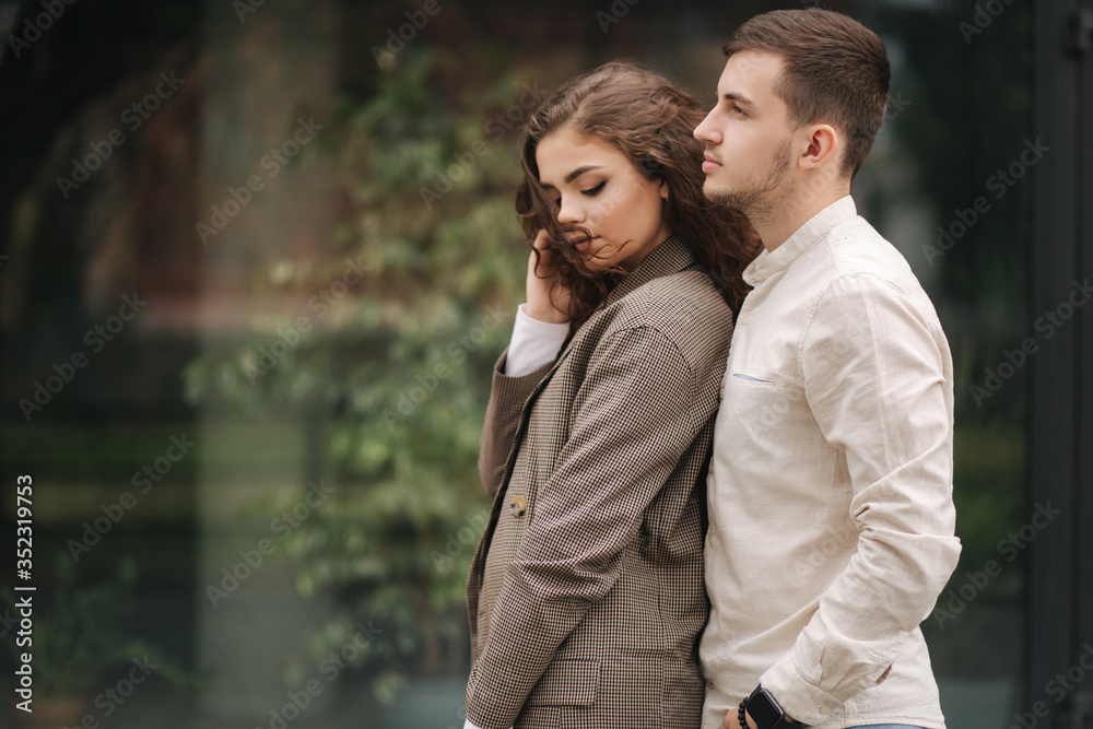 Portrait of couple in love. Young man and woman with curly hair outdoors
