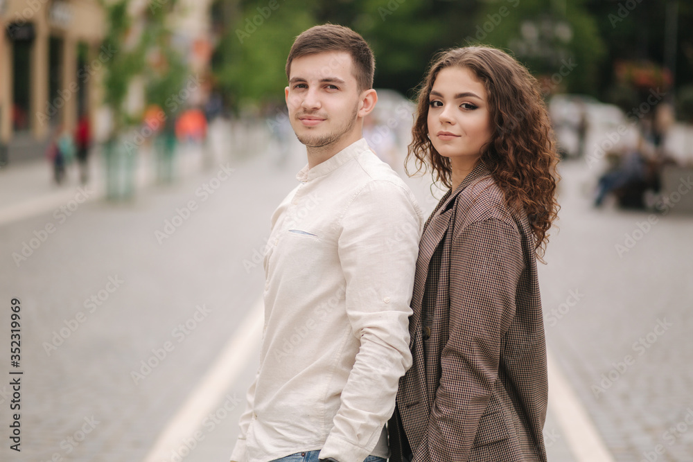Happy couple walking in the city. Attractive young woman and handsome young man in centre of the city. Smiled people Happy couple walking in the city. Attractive young woman and handsome young man in centre of the city. Smiled people
