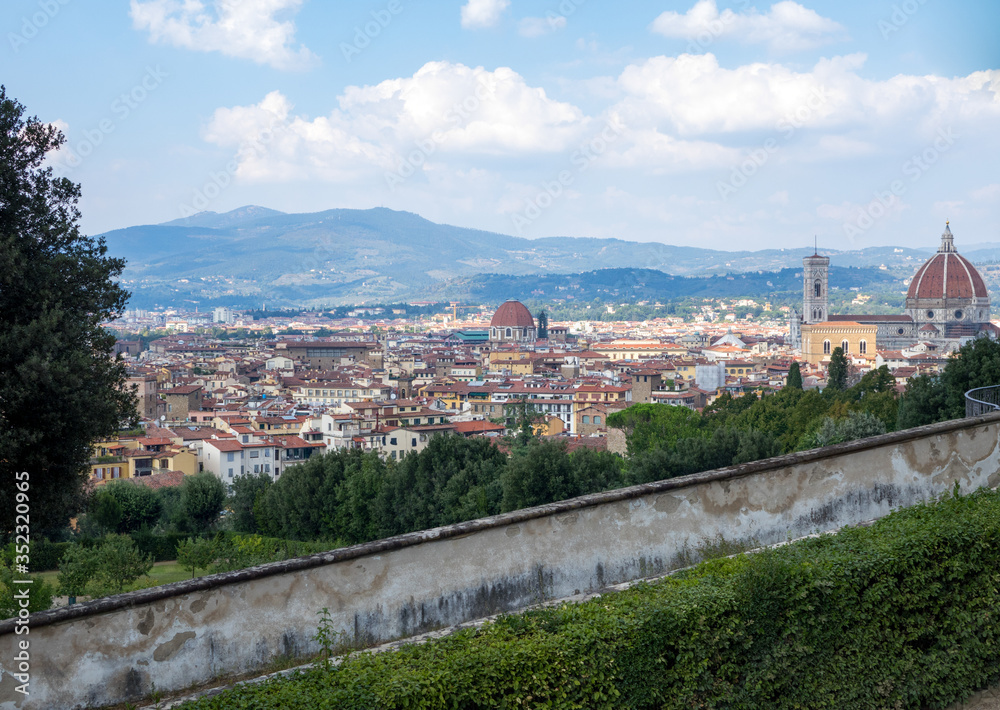 Landscape of city of Florence from top of a hill with a foreground sidewalk and grass / loan