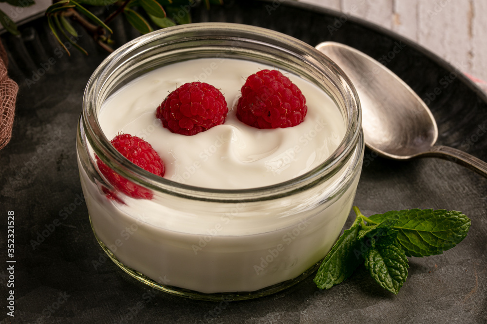 Yoghurt with raspberries on a metal plate