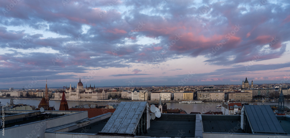Panoramic view from Pest house balcony of Danube river side with Hungarian Parliament at dusk Panoramic view from Pest house balcony of Danube river side with Hungarian Parliament at dusk