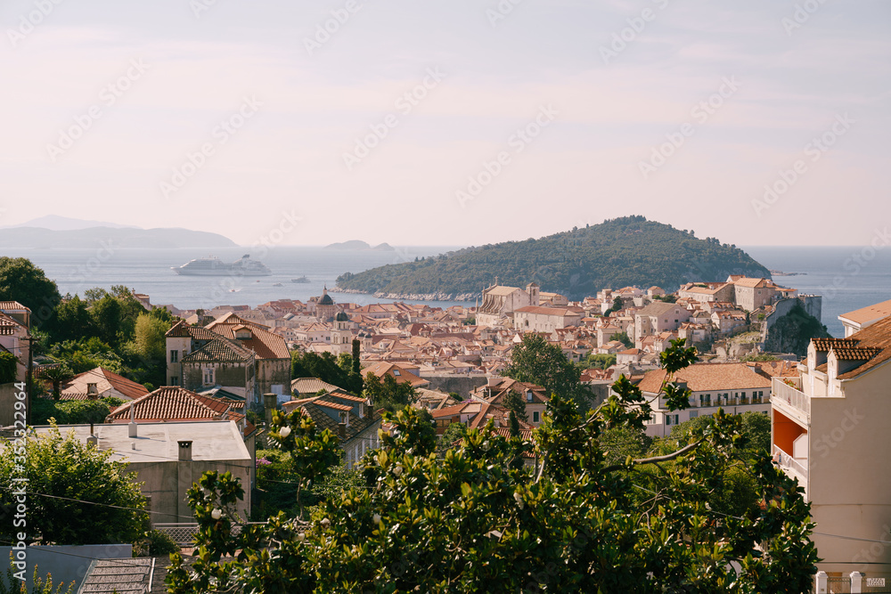 The old city of Dubrovnik on the background of the island of Lokrum and a cruise liner at dawn.