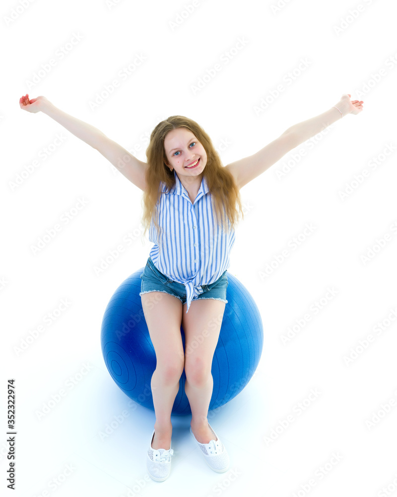little girl is engaged in fitness with a ball.