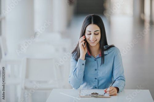 Картината върху платно Smiling recruiter calling a job candide on the phone to schedule an interview