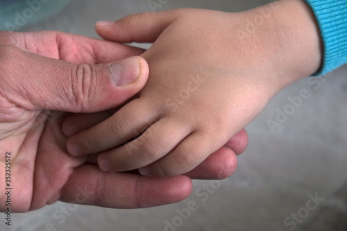 a sleeping baby and a loving father, a father holding and loving the hand of his child,