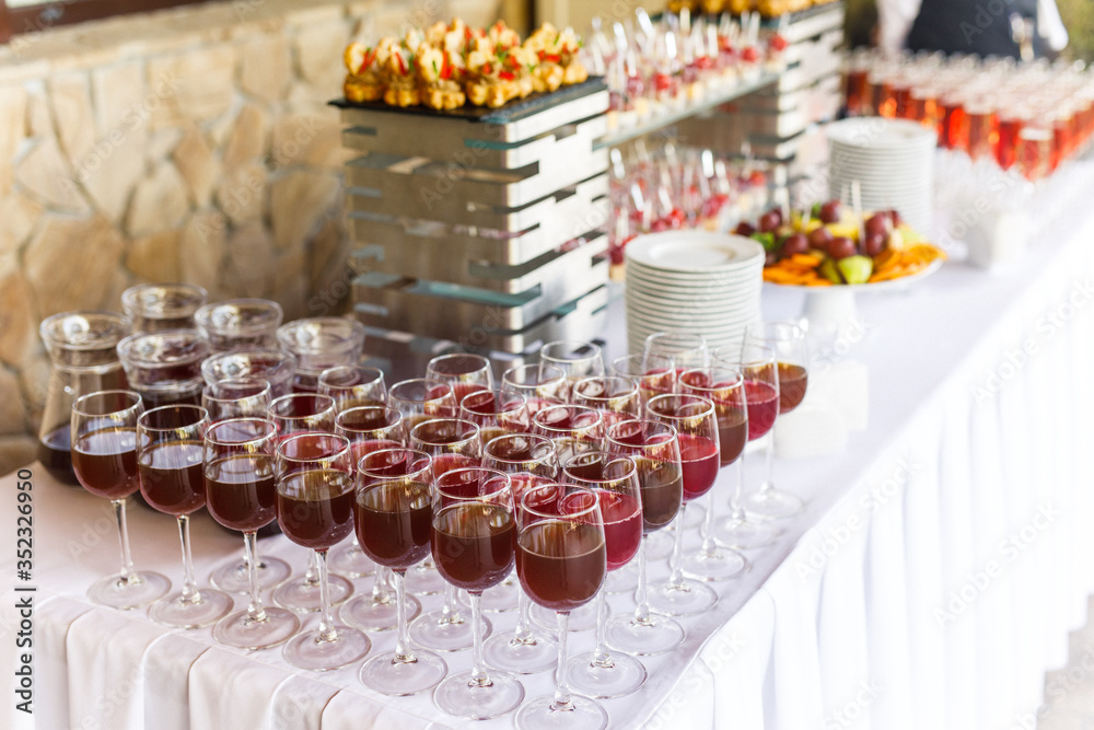 on a wooden table in the wedding banquet area are snacks, fruits, sweet cakes and muffins and lemonade drink