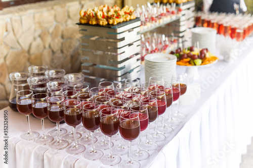 on a wooden table in the wedding banquet area are snacks  fruits  sweet cakes and muffins and lemonade drink