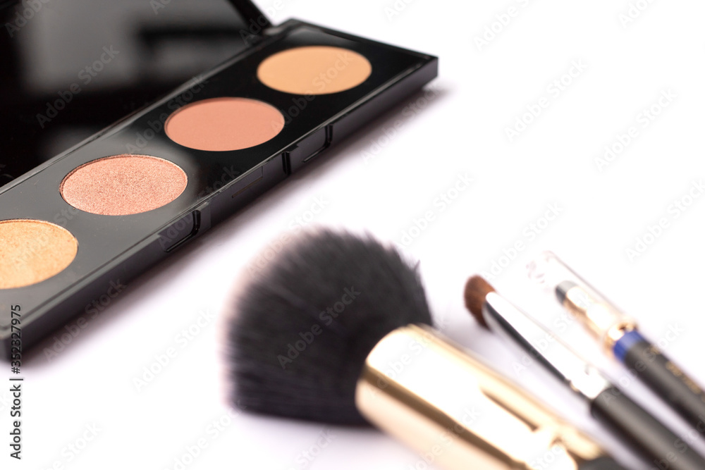 Three makeup brushes and highlighter on a white background. Cosmetical tools Three makeup brushes and highlighter on a white background. Cosmetical tools