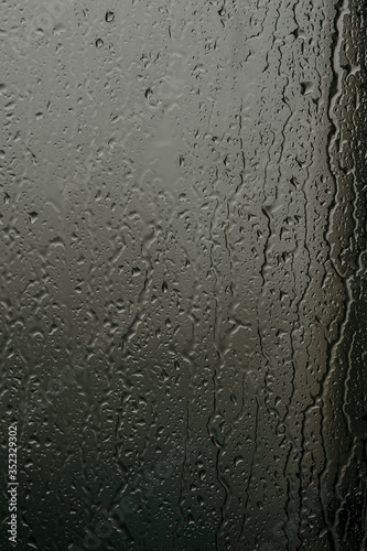 Raindrops on glass, view from the window, heavy rain, bad weather, loneliness, isolation. The texture of the wet surface, background, beautiful wallpaper. Nature is crying.