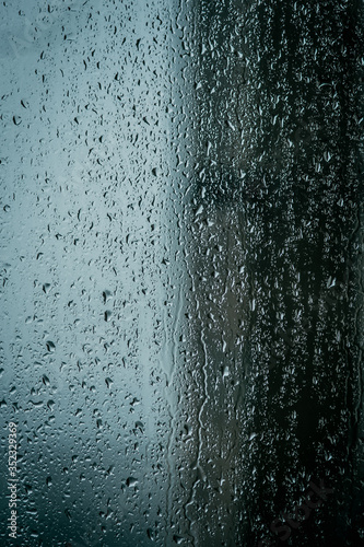 Raindrops on glass, view from the window, heavy rain, bad weather, loneliness, isolation. The texture of the wet surface, background, beautiful wallpaper. Nature is crying.
