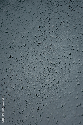 Raindrops on glass, view from the window, heavy rain, bad weather, loneliness, isolation. The texture of the wet surface, background, beautiful wallpaper. Nature is crying.