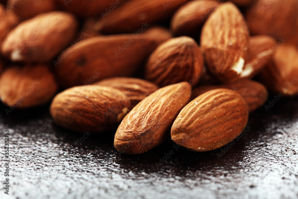 Almonds on a rustic background and almond in bowl. Almonds on a rustic background and almond in bowl.