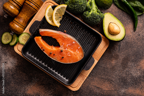 Raw salmon steak in a pan with healthy products. Healthy eating concept, food background. Top view.