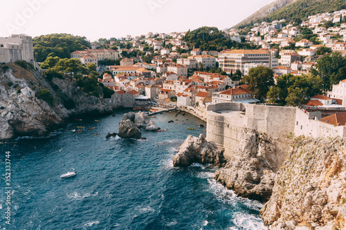 View from the wall of the old city of Dubrovnik on the fort Lovrijenac fortress on the cliff and the bay with a pier.