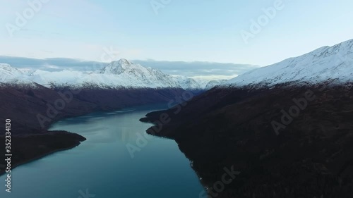 Drone shoot the shores of a frozen lake between snow-capped mountains (Eklutna Lake, Alaska, USA) photo