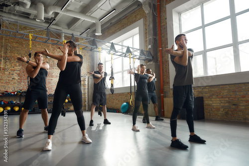 Love yourself enough to work harder. Full-length shot of diverse men and women working out together in industrial gym. Group training concept