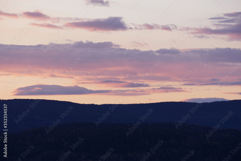 Beautiful colorful sky after sunset over mountains.