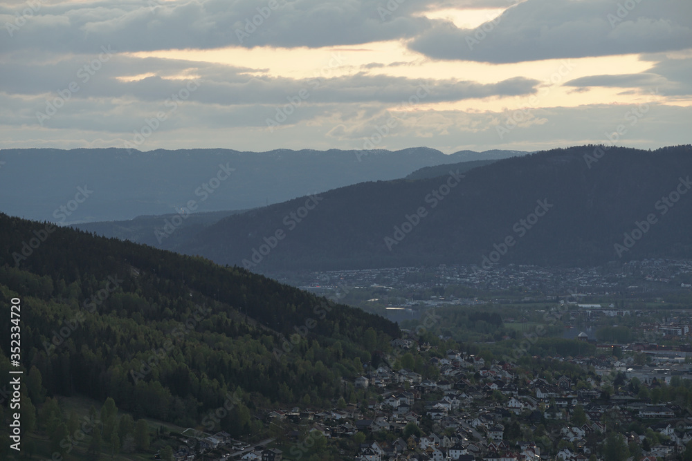 View at city cituated in a valley between mountains in evening time.