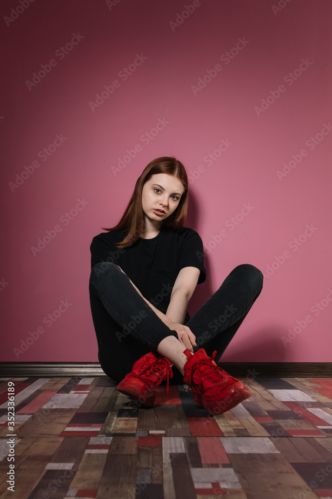 Girl in black poses on a pink background Girl in black poses on a pink background