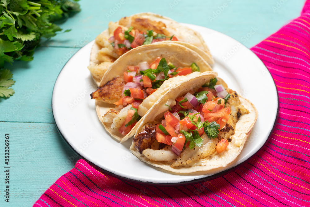 Mexican fish tacos also called Baja with fresh sauce on turquoise background Mexican fish tacos also called Baja with fresh sauce on turquoise background