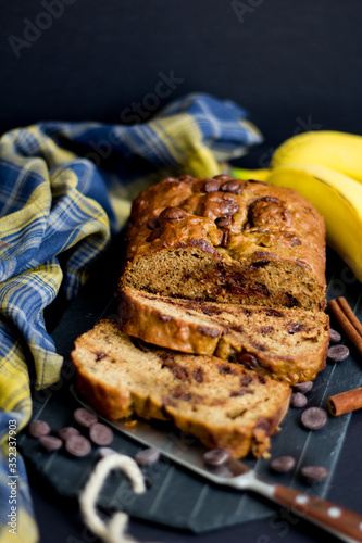 Banana bread with chocolate chips with a plaid napkin and dark background