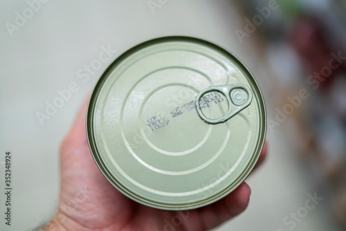 man holding a can of food in his hand in the supermarket