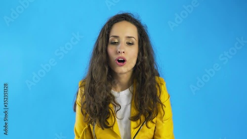 A woman feels pleasure close her eyes in Studio with blue Background.