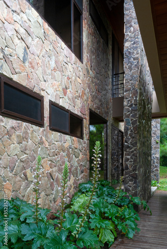 Fototapeta Naklejka Na Ścianę i Meble -  Exterior corridor in modern house in Latin America, avant-garde design, high-level engineering, use of materials such as stone and glass.