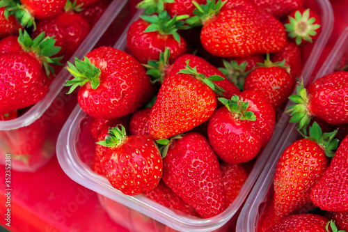 Tasty juicy strawberry berries in boxes, on the market