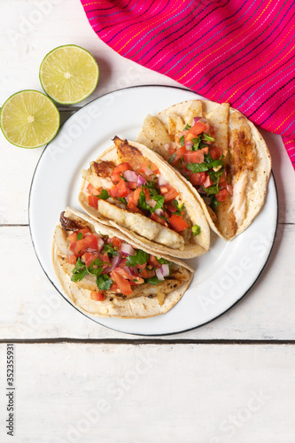 Mexican fish tacos also called Baja with fresh sauce on white background