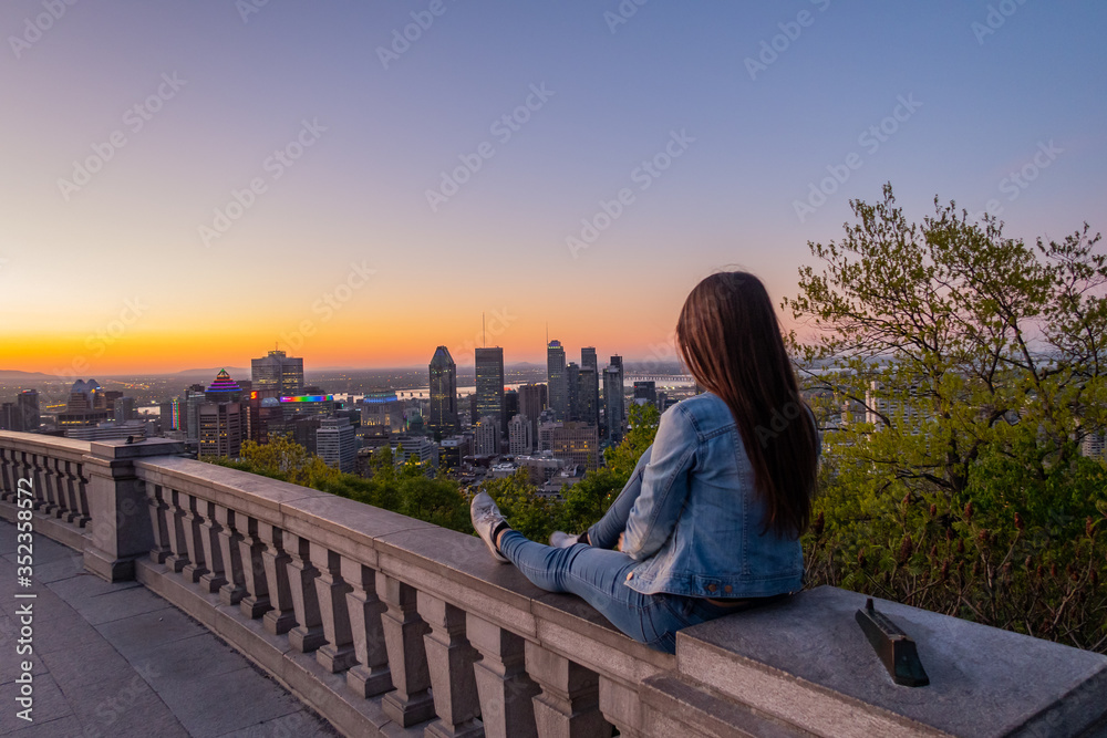Montreal, Canada - may 2020; young woman admiring the sunrise from the Kondiaronk belvedere, in the Mont-Royal park - obrazy, fototapety, plakaty 