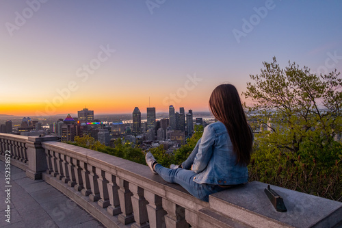 Montreal, Canada - may 2020; young woman admiring the sunrise from the Kondiaronk belvedere, in the Mont-Royal park photo